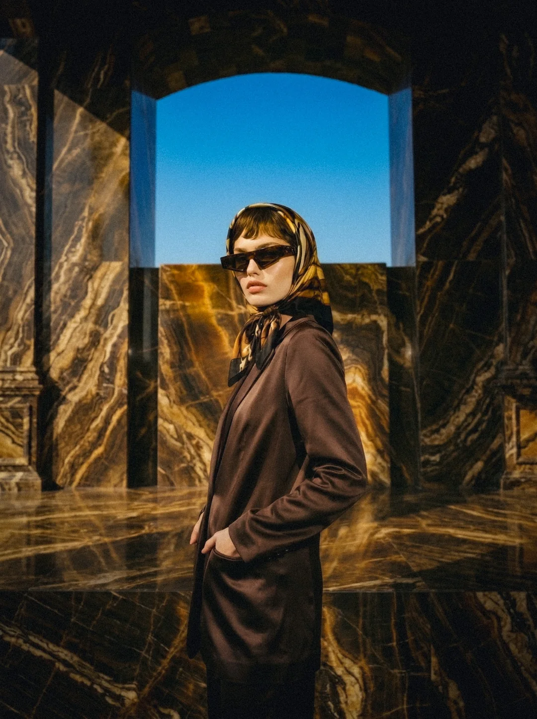 AI fashion campaign visual: model wearing tortoiseshell sunglasses in marble architecture